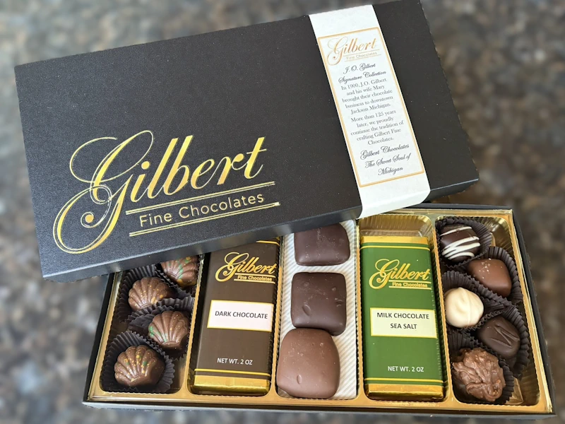gilbert-chocolates-new-signature-collection-corporate-gift-giving closeup photo of boxed chocolates with Gilbert Signature lid overlaying the open box